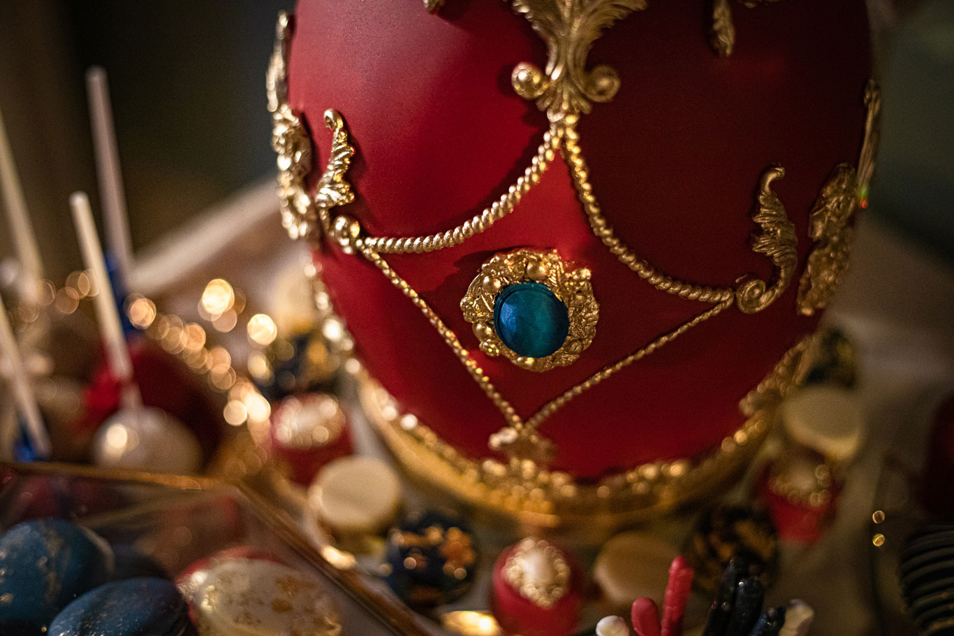 A closeup of a Fabergé egg inspired cake by GC Couture with handpainted gold details