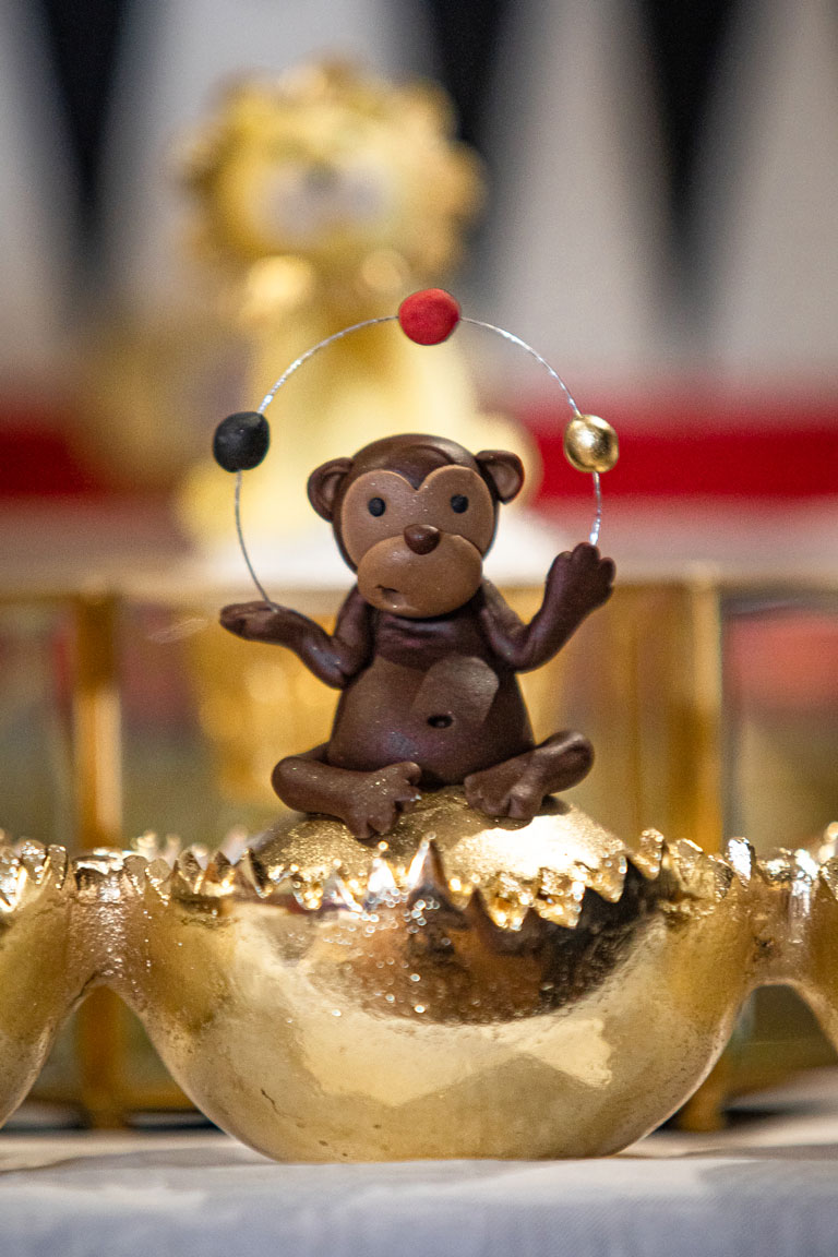 A handmade cake monkey sitting on a cupcake