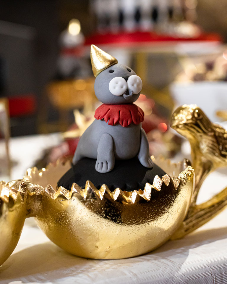 A seal shaped cake model sitting on a cupcake