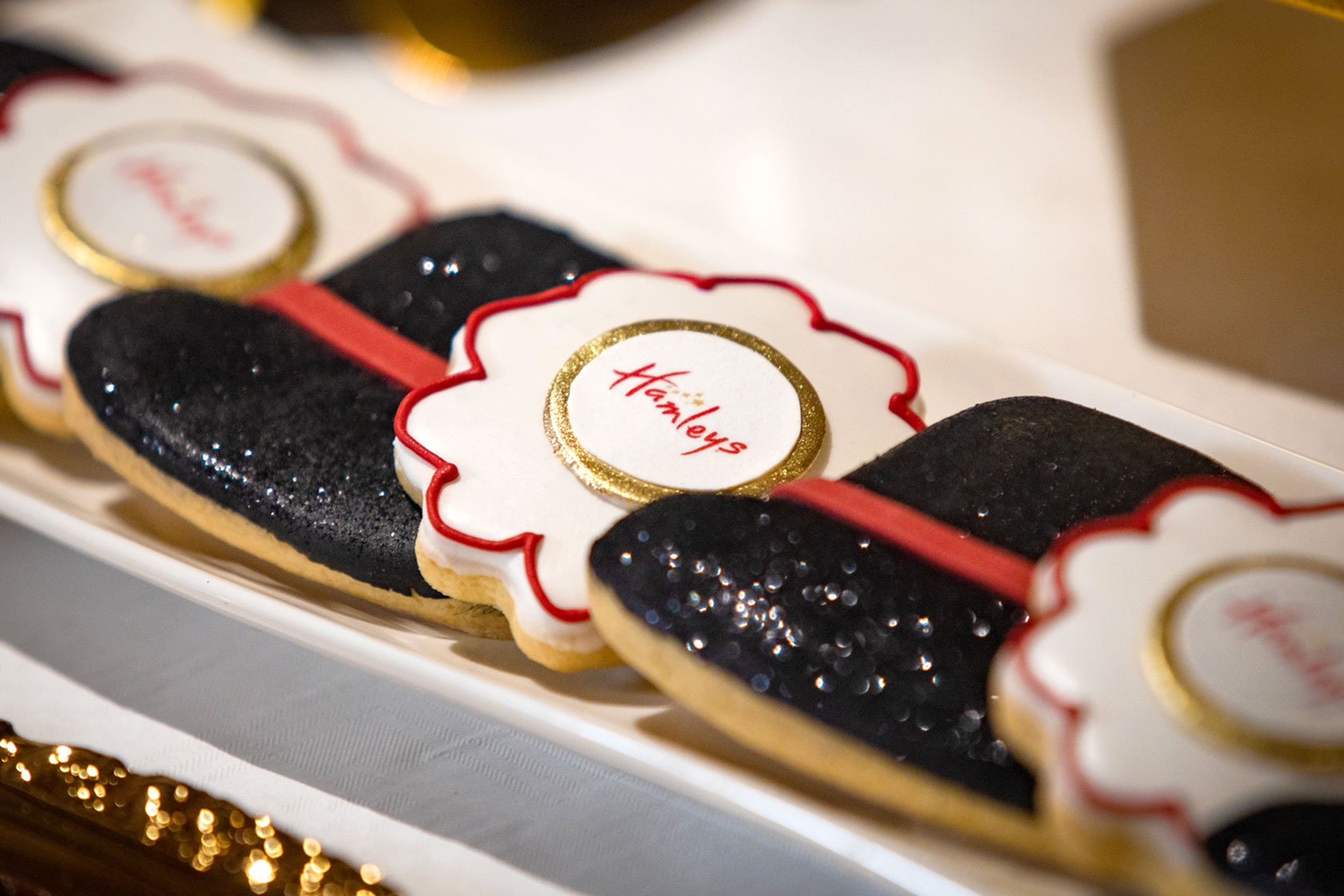 Cookies in the shape of black top hats with Hamleys logo