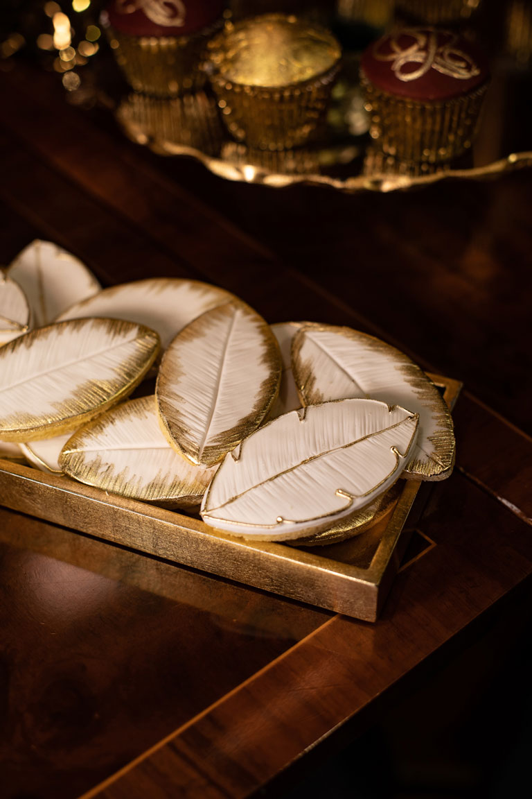 A selection of elegant leaf shaped cookies by GC Couture with gold piping around the edges